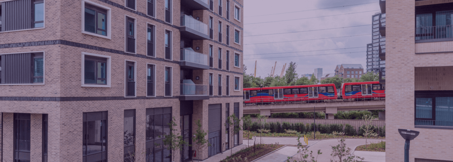 Exterior of Wallbrook Gardens housing with a running train in the background