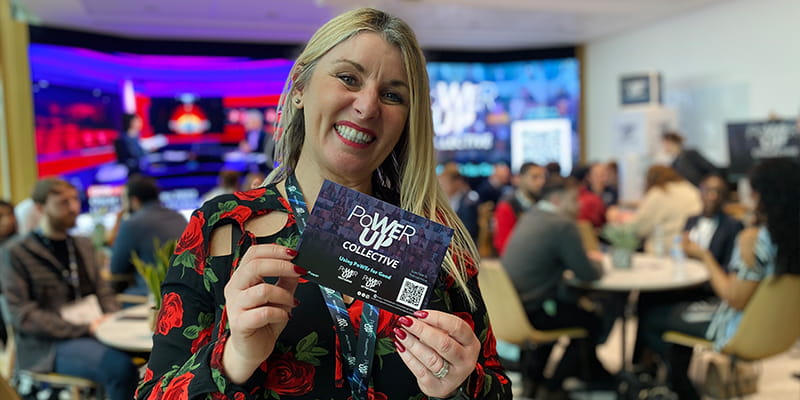 Woman holding up Power Up event card